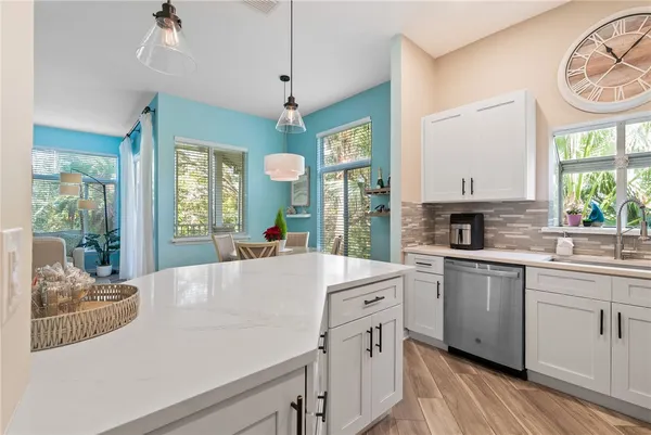 a kitchen with a stove a sink and a clock on the wall