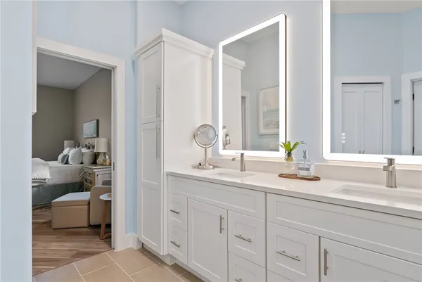 a bathroom with double vanity sinks and a shower