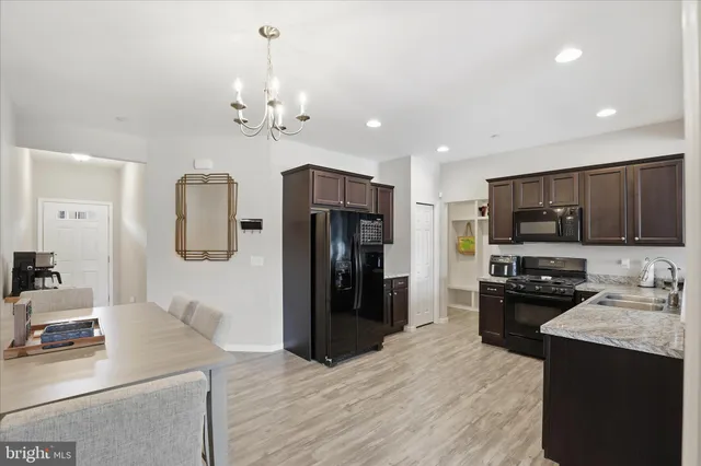 a kitchen with a refrigerator a stove top oven a sink dishwasher and wooden floor