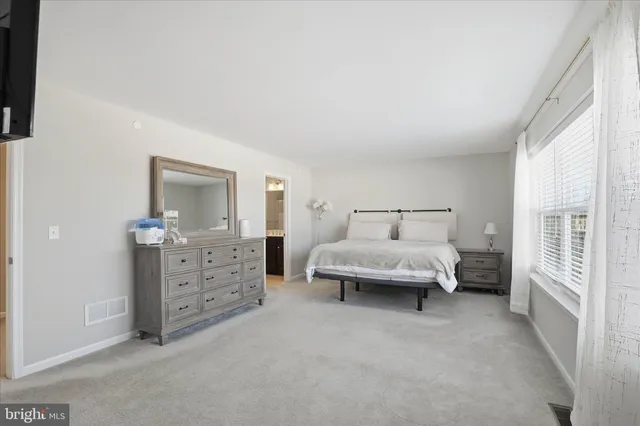 a spacious bedroom with a bed and wooden floor