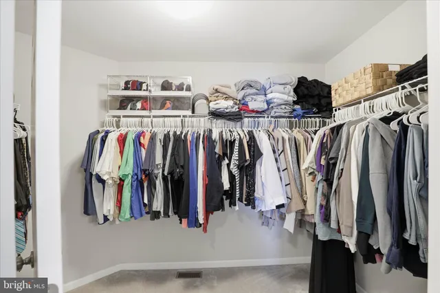 a view of walk in closet with clothes