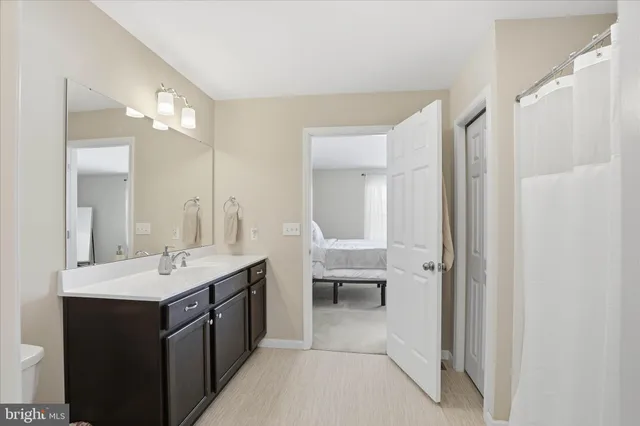 a en suite bathroom with a double vanity sink a mirror and a shower