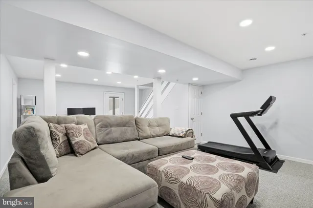 a living room with furniture and a ceiling fan