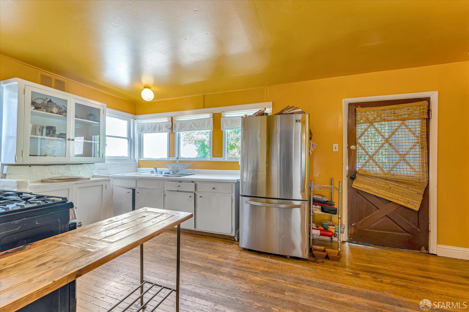 1917 Oregon Street Berkeley, CA 94703 - Photo 16 of 43 a kitchen with stainless steel appliances granite countertop a refrigerator a stove and a sink with wooden floor