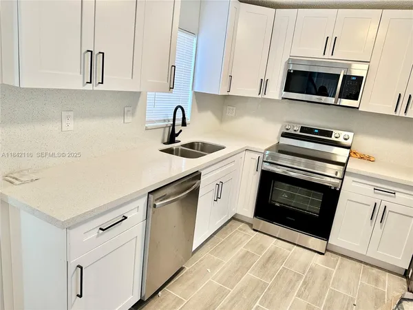 a kitchen with stainless steel appliances white cabinets and a stove a oven with white countertops