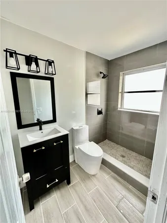 a bathroom with a toilet sink and mirror