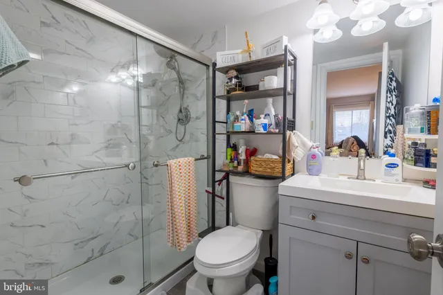 a bathroom with a sink toilet vanity and shower