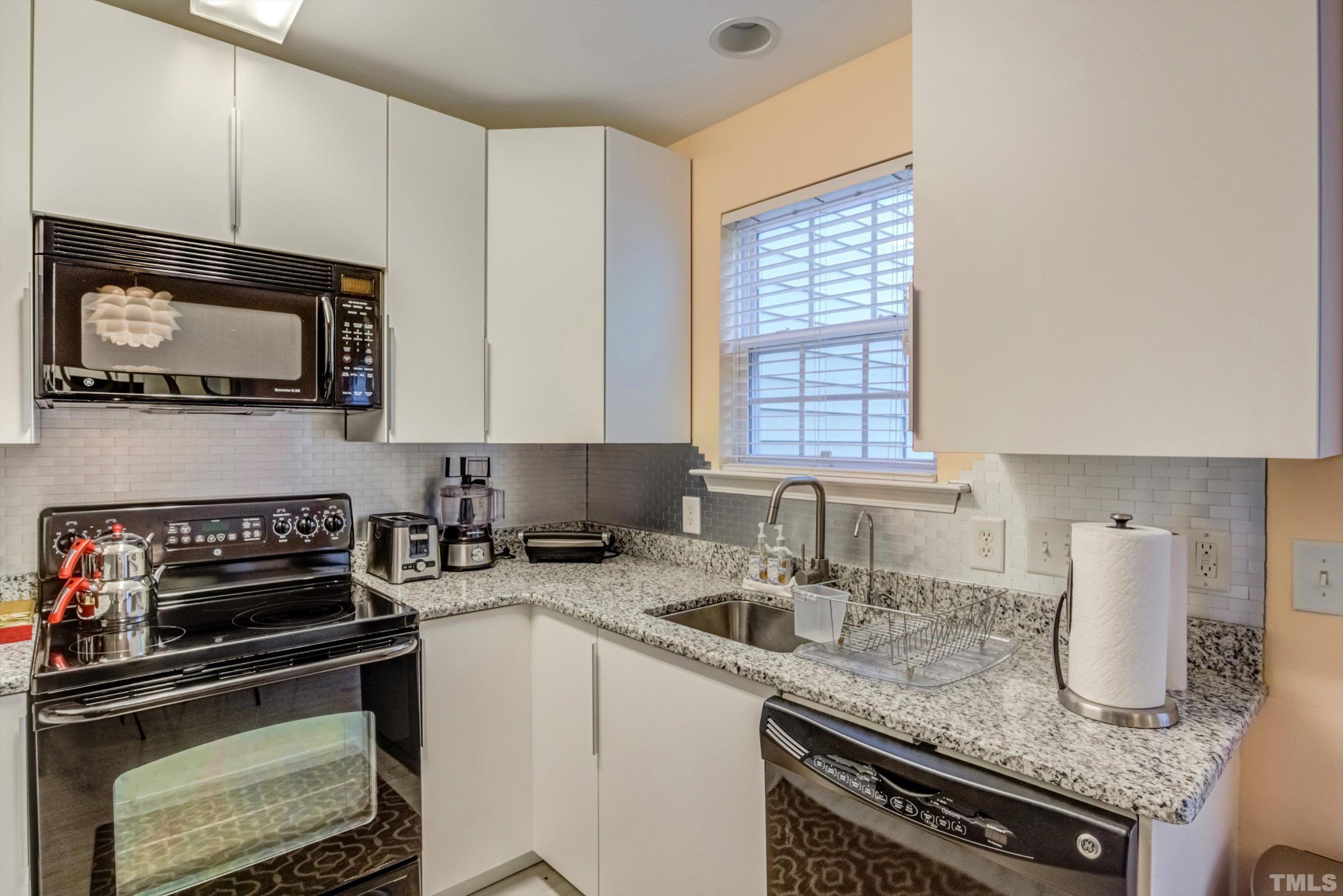 7846 Averette Field Drive Raleigh, NC 27616 - Photo 7 of 21 a kitchen with granite countertop a sink a stove and cabinets