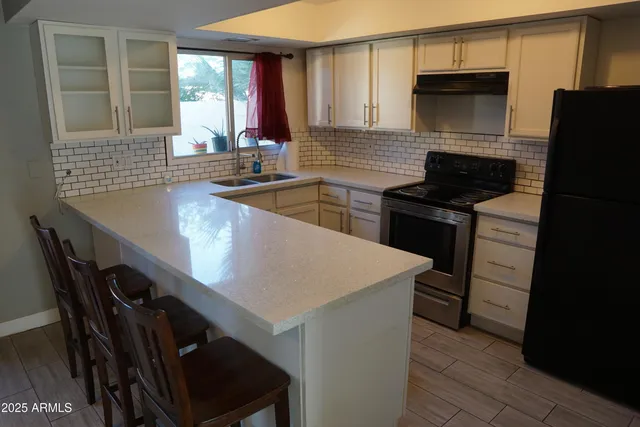 a kitchen with a table chairs refrigerator and microwave