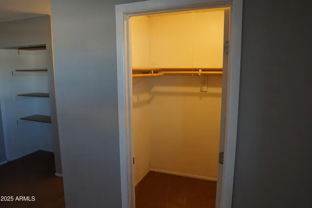 a view of walk in closet with empty racks