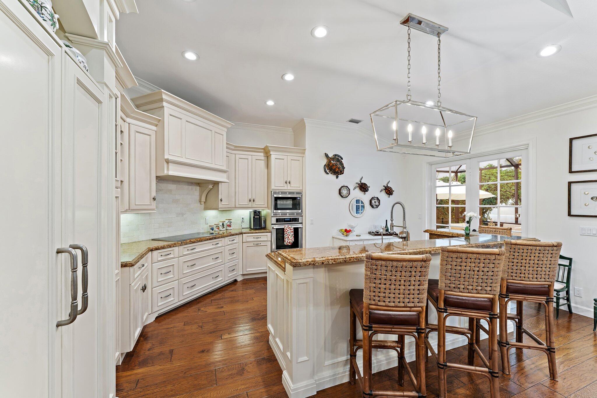 3230 West Channel Circle Jupiter, FL 33477 - Photo 26 of 67 a kitchen with stainless steel appliances kitchen island granite countertop a dining table chairs and white cabinets