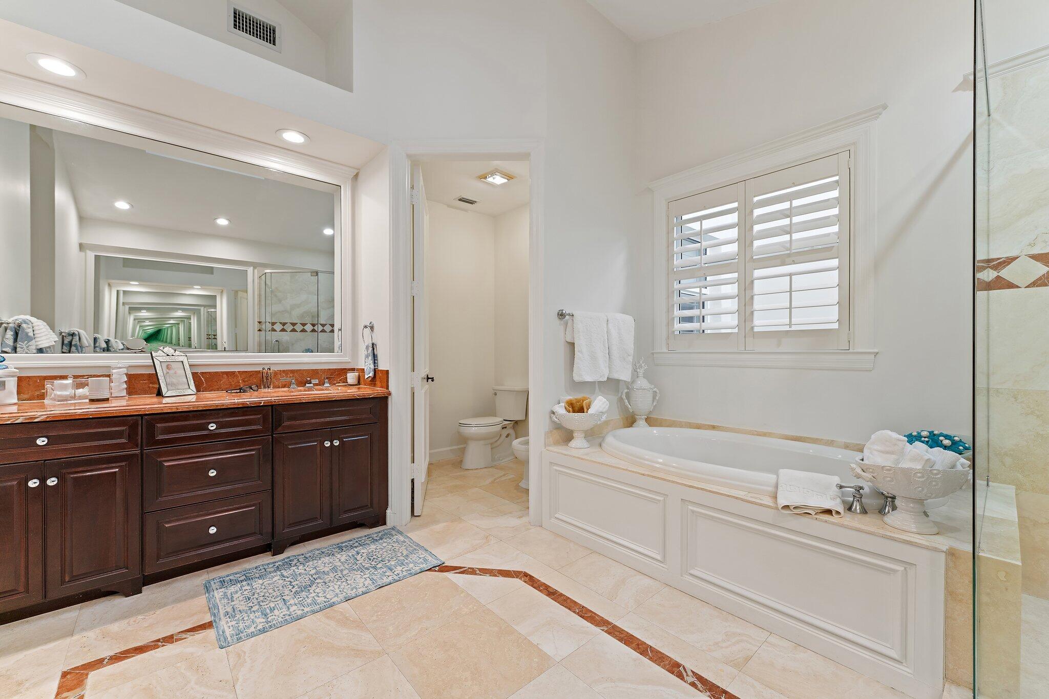 3230 West Channel Circle Jupiter, FL 33477 - Photo 36 of 67 a spacious bathroom with a tub sink double vanity granite and tub