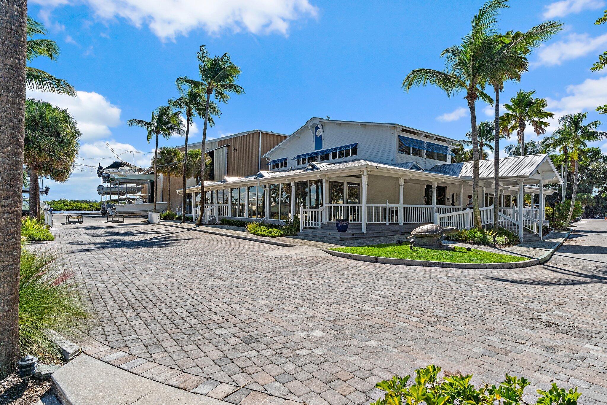 3230 West Channel Circle Jupiter, FL 33477 - Photo 60 of 67 a view of a house with a yard and potted plants