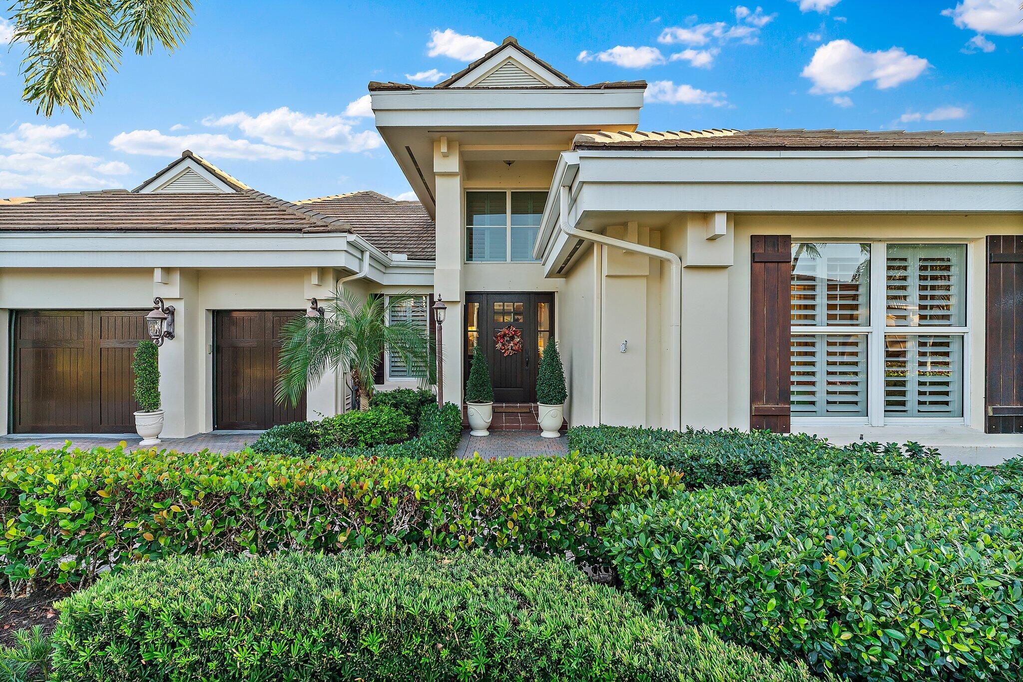 3230 West Channel Circle Jupiter, FL 33477 - Photo 6 of 67 a front view of a house with garden