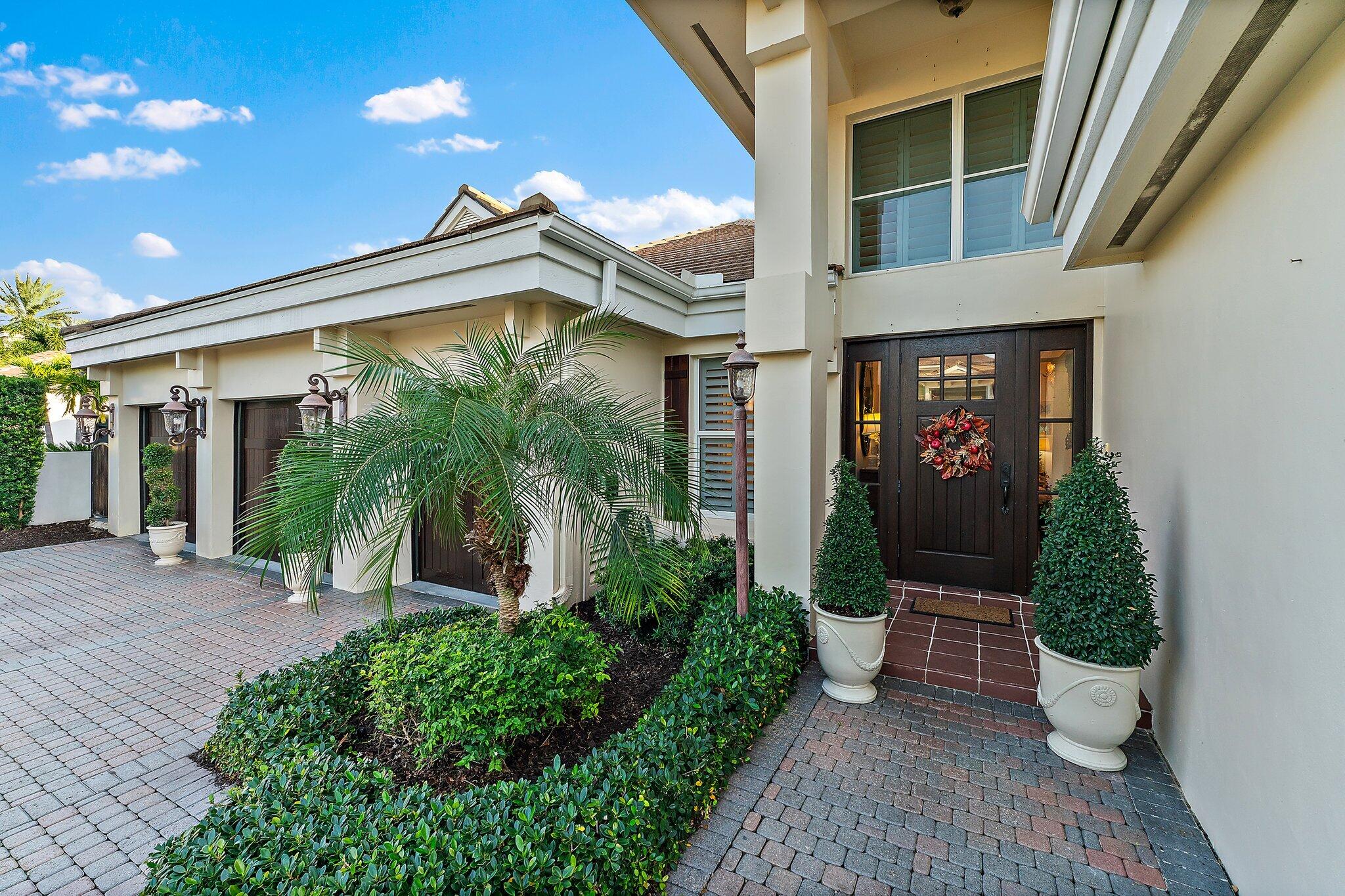 3230 West Channel Circle Jupiter, FL 33477 - Photo 8 of 67 a view of a house with potted plants and a table and chairs