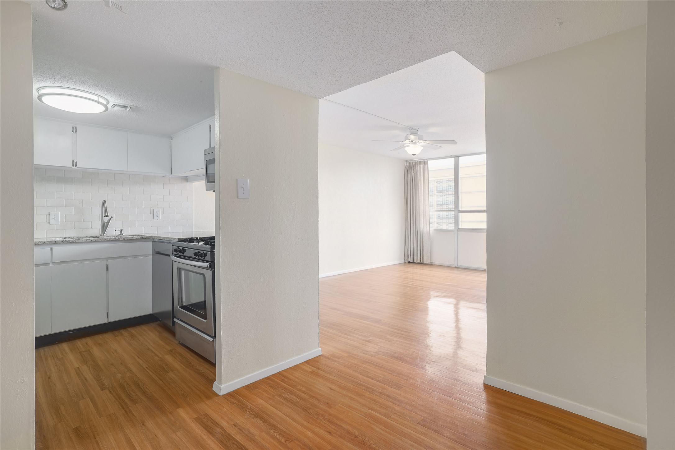 1800 Lavaca Street, Unit A508 Austin, TX 78701 - Photo 13 of 25 Kitchen with white cabinetry, a tiled backsplash, and stainless steel appliances