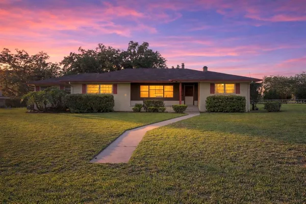 an empty room with wooden floor and a ceiling fan