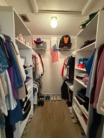 a view of walk in closet with clothes and shoes