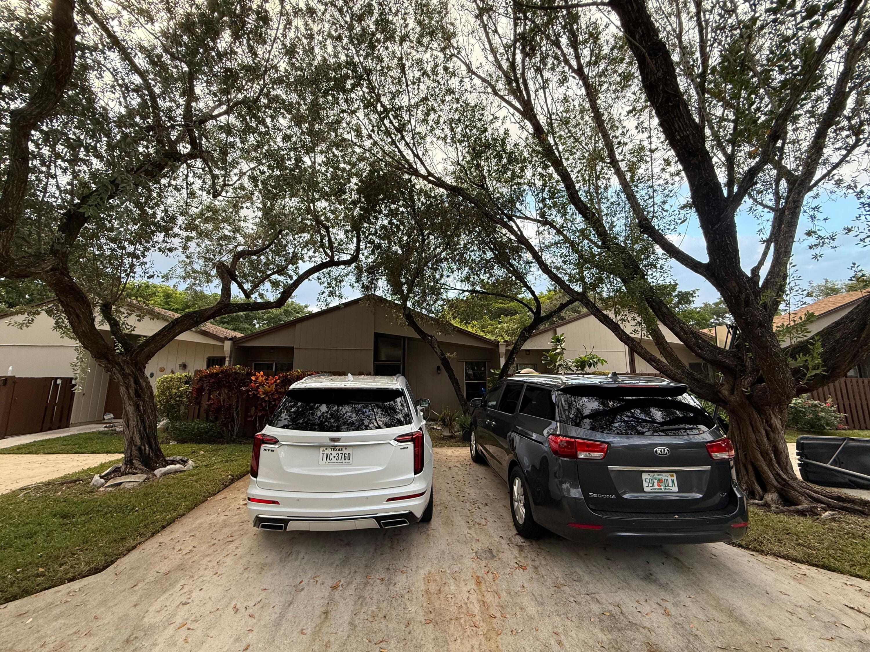 22293 Misty Woods Way Boca Raton, FL 33428 - Photo 3 of 23 a car parked in front of a white house