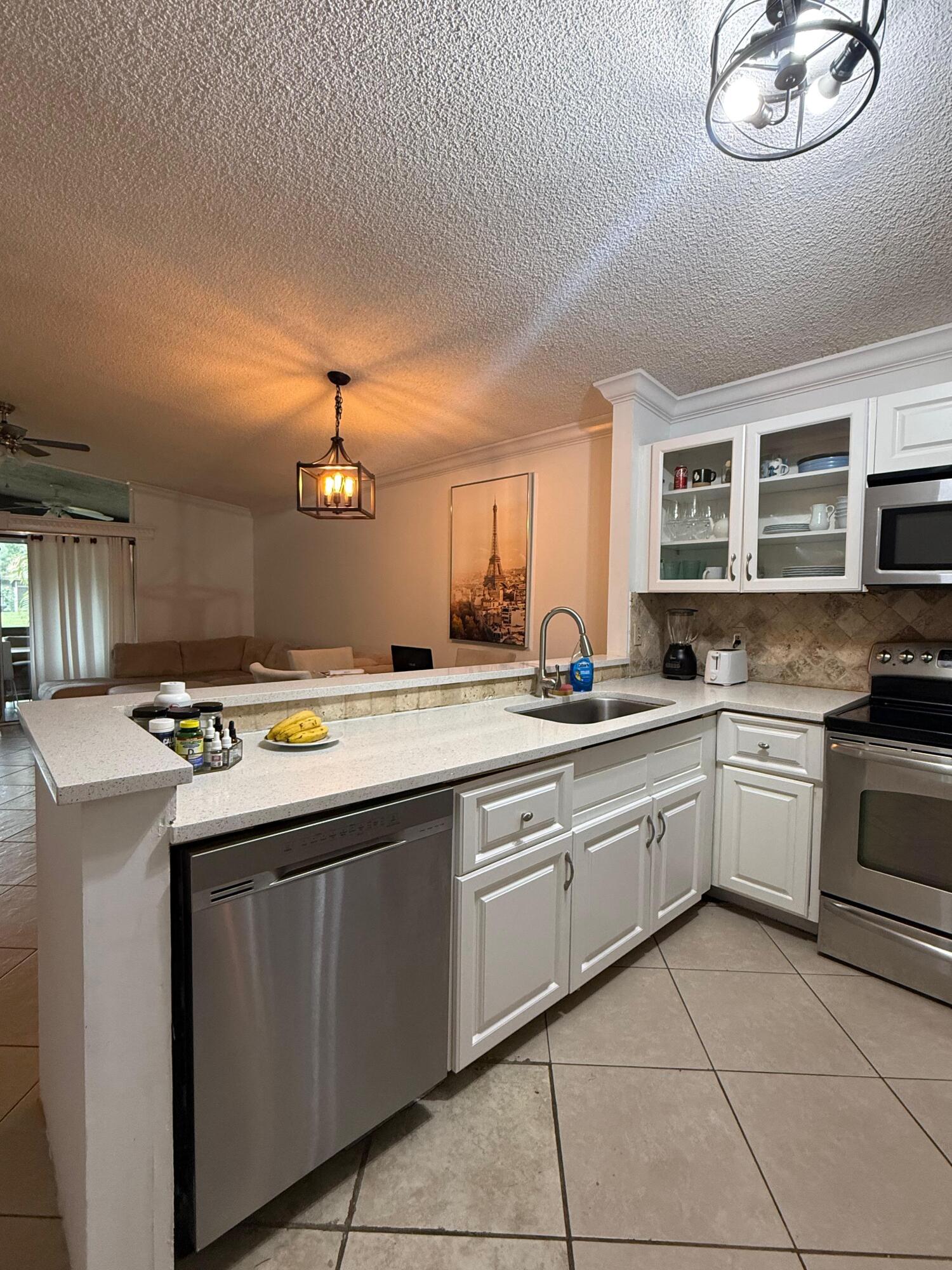 22293 Misty Woods Way Boca Raton, FL 33428 - Photo 7 of 23 a kitchen with kitchen island granite countertop a sink and a stove
