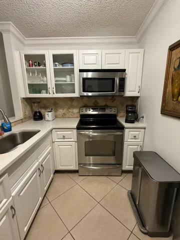 a kitchen with stainless steel appliances a stove a sink and a microwave