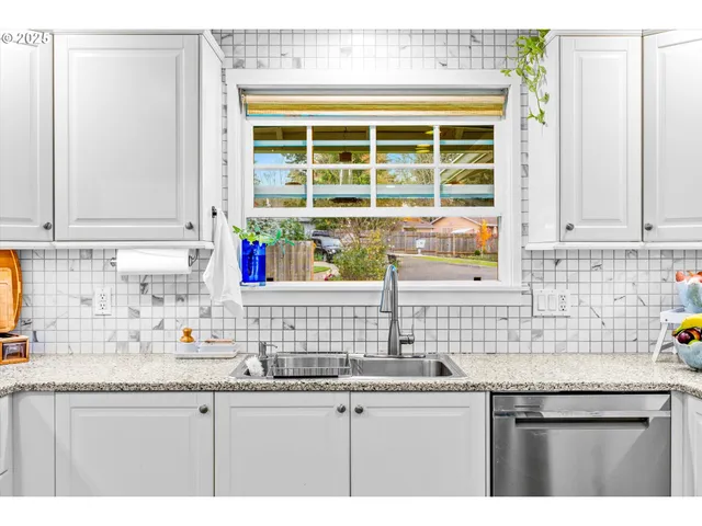 a kitchen with granite countertop a refrigerator a sink a stove a dining table and chairs