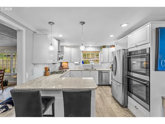 a kitchen with granite countertop a sink stainless steel appliances and cabinets