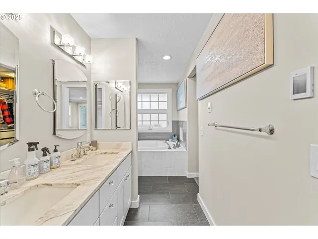 a bathroom with a sink a bathtub and a window