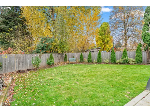 a view of a house with backyard and tree