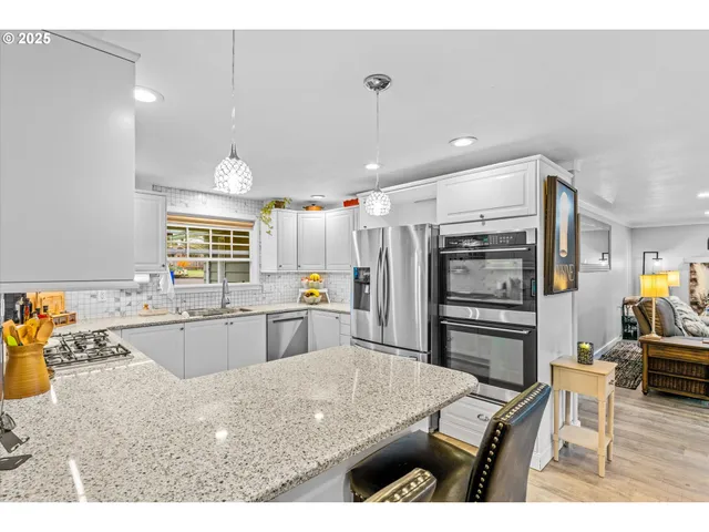a kitchen with stainless steel appliances granite countertop a sink dishwasher and a stove with granite countertops