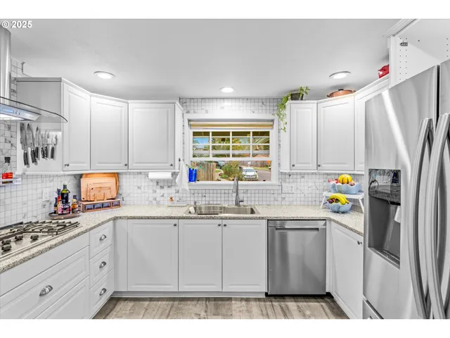 a kitchen with stainless steel appliances granite countertop a sink and a window