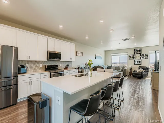 a kitchen with a table chairs refrigerator and cabinets