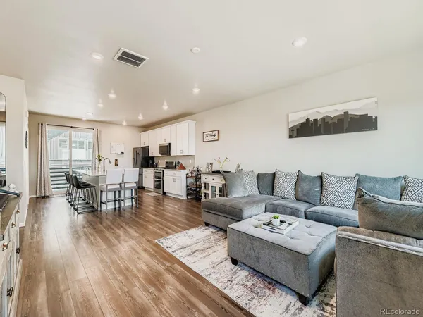 a living room with furniture and wooden floor