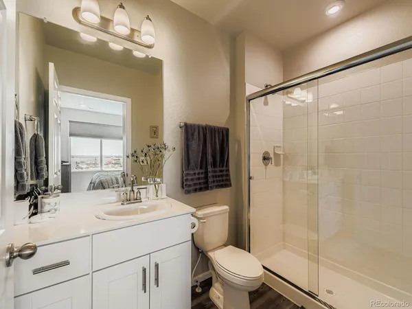 a bathroom with a sink a toilet a mirror and shower