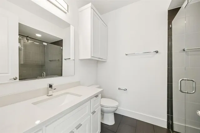 a bathroom with a sink a toilet and shower