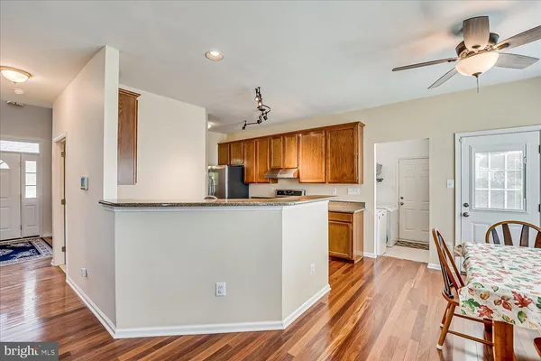 a kitchen with sink a refrigerator and wooden floor