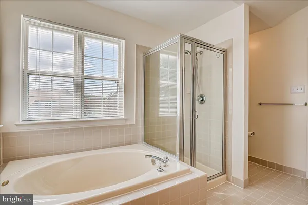 a white bath tub sitting next to a shower