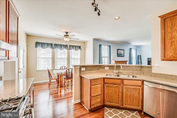 a view of a kitchen counter space wooden floor and a living room