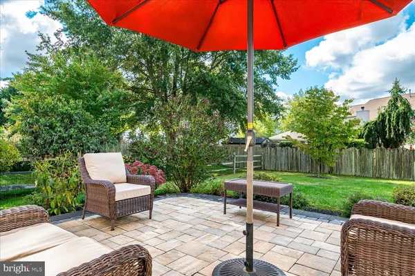 a view of a sitting area with a table and chairs under an umbrella