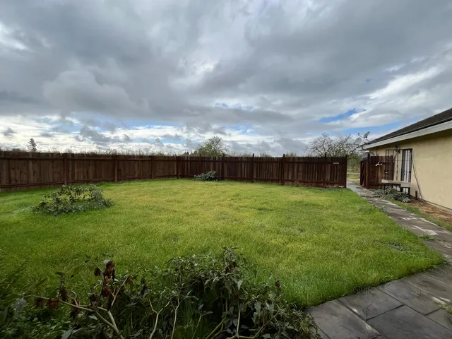 a view of a house with backyard and a garden