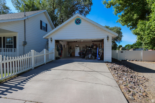 270 East 100 North Monroe, UT 84754 - Photo 5 of 65 Detached garage with white siding, concrete driveway, and exterior lighting fixtures