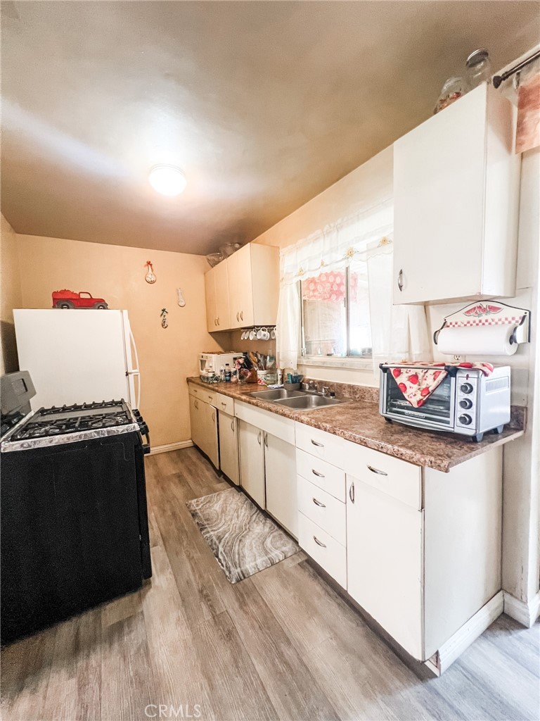 8206 Jackson Street Paramount, CA 90723 - Photo 4 of 9 a kitchen with granite countertop a stove sink and cabinets