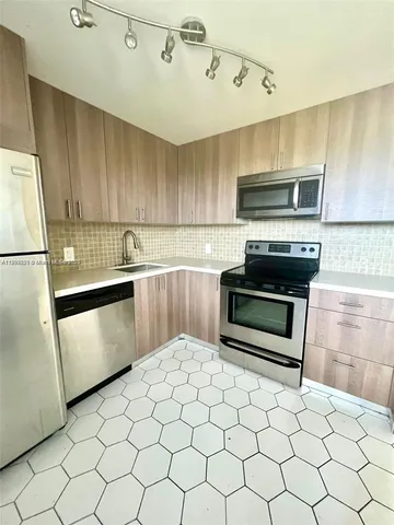 a kitchen with stainless steel appliances a stove a sink and a refrigerator