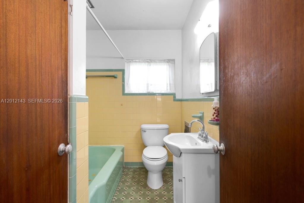 5651 Northwest 3rd Street Miami, FL 33126 - Photo 17 of 21 a bathroom with a toilet a sink and mirror