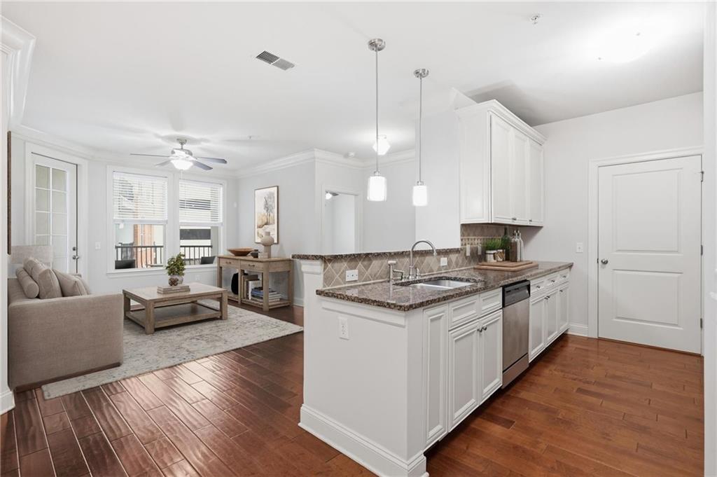 901 Abernathy Road Northeast, Unit 3080 Atlanta, GA 30328 - Photo 3 of 21 a large kitchen with kitchen island a stove a sink a center island and wooden floor