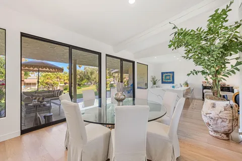 a living room with furniture a dining table and a large window