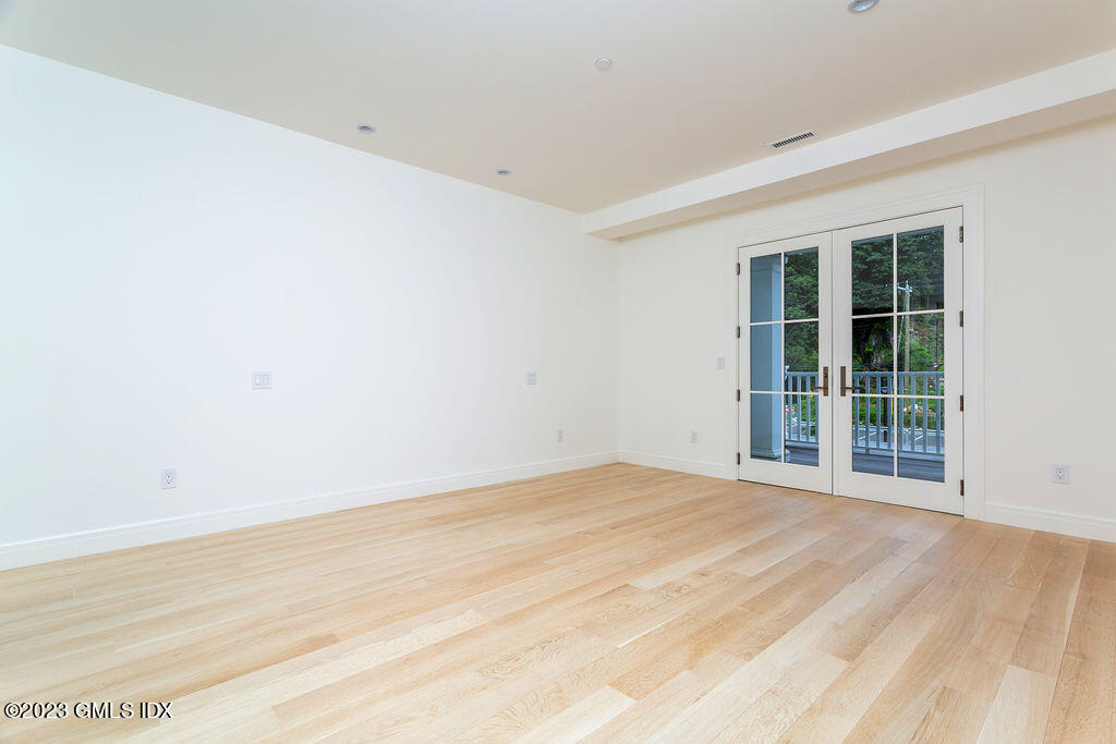 89 River Road, Unit 203 Cos Cob, CT 06807 - Photo 13 of 27 an empty room with wooden floor and windows