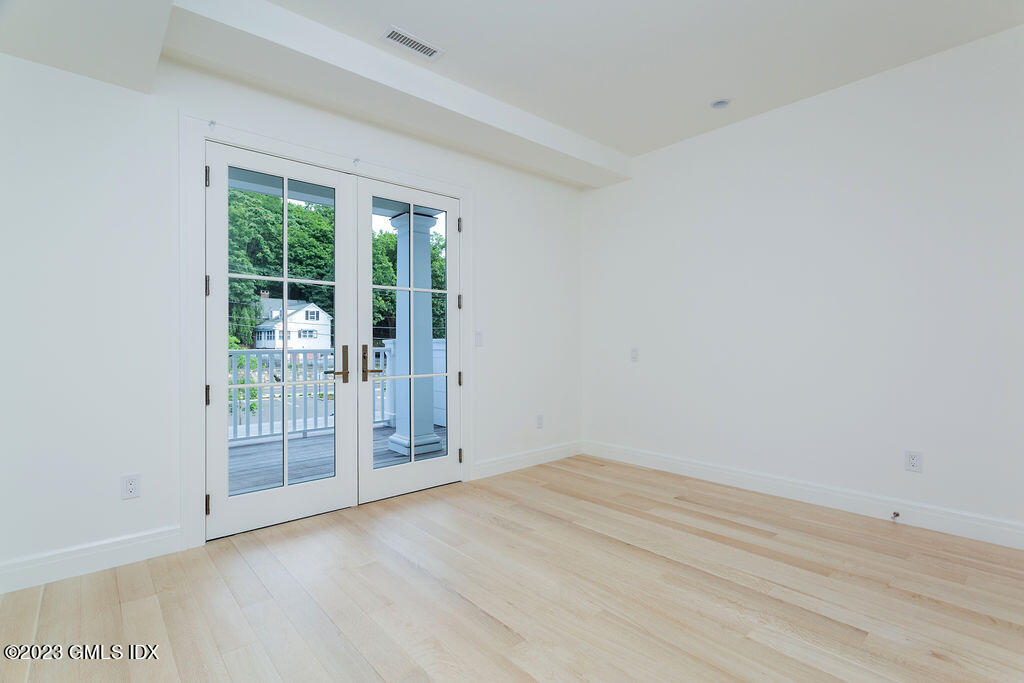 89 River Road, Unit 203 Cos Cob, CT 06807 - Photo 19 of 27 an empty room with wooden floor and windows