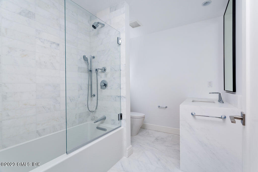89 River Road, Unit 203 Cos Cob, CT 06807 - Photo 20 of 27 a bath room with a toilet and a bath tub