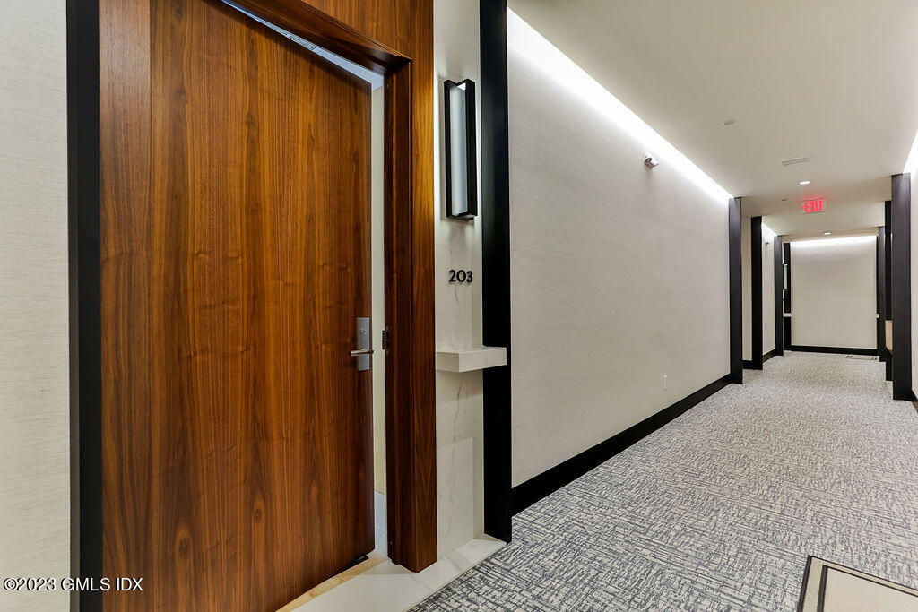 89 River Road, Unit 203 Cos Cob, CT 06807 - Photo 2 of 27 a view of a hallway with wooden floor